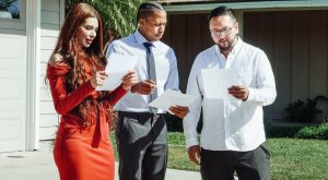 three people outside a home